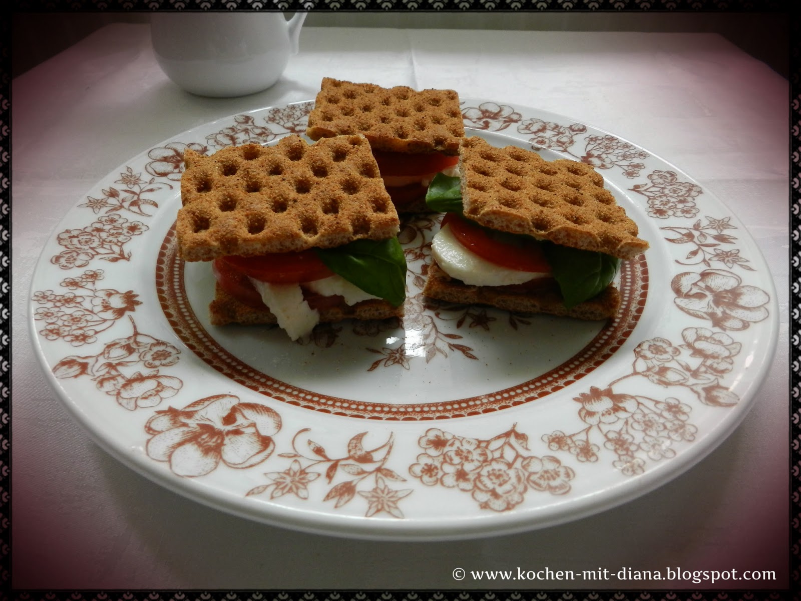 Cracker mit Mozzarella und Tomate