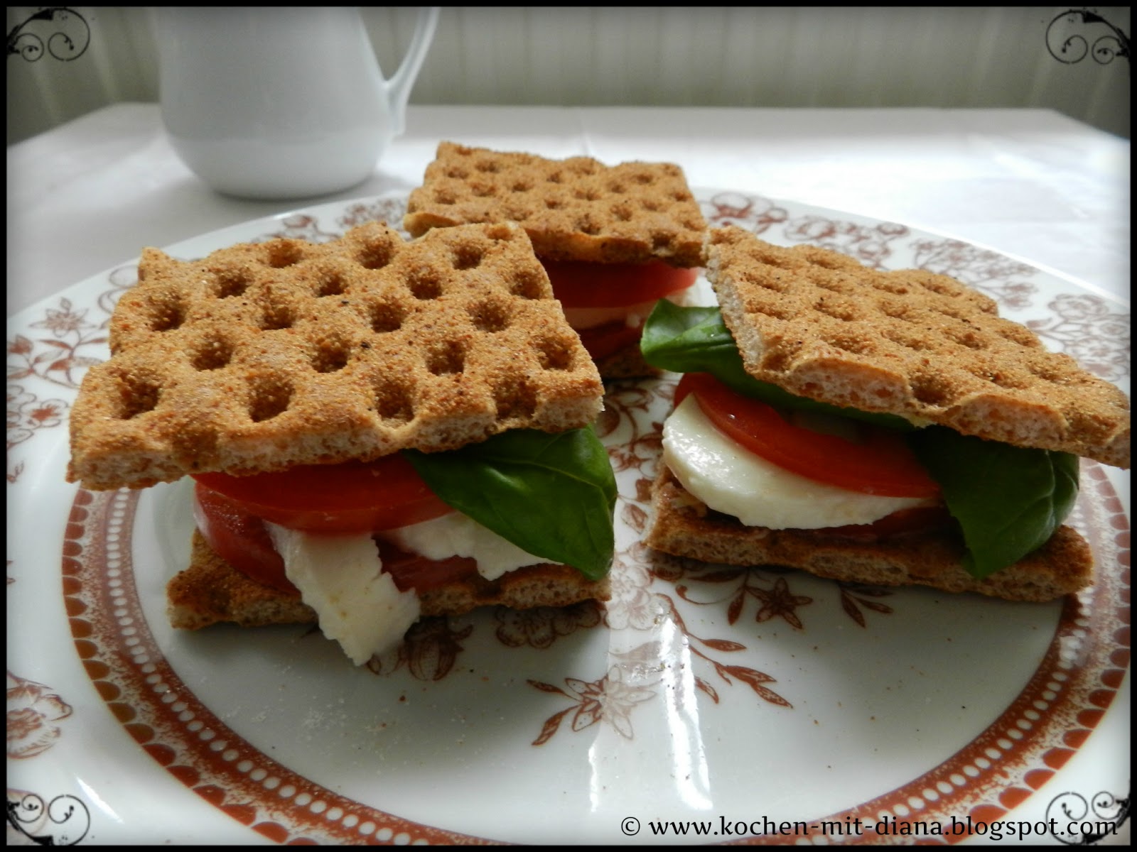 Cracker mit Mozzarella und Tomate